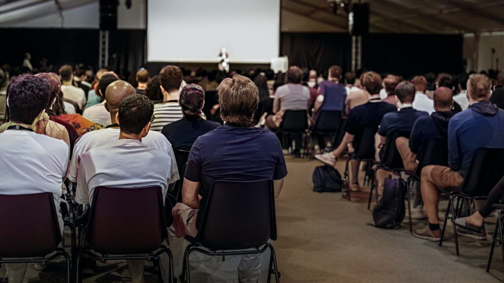 Group of people in hall or auditorium with screen